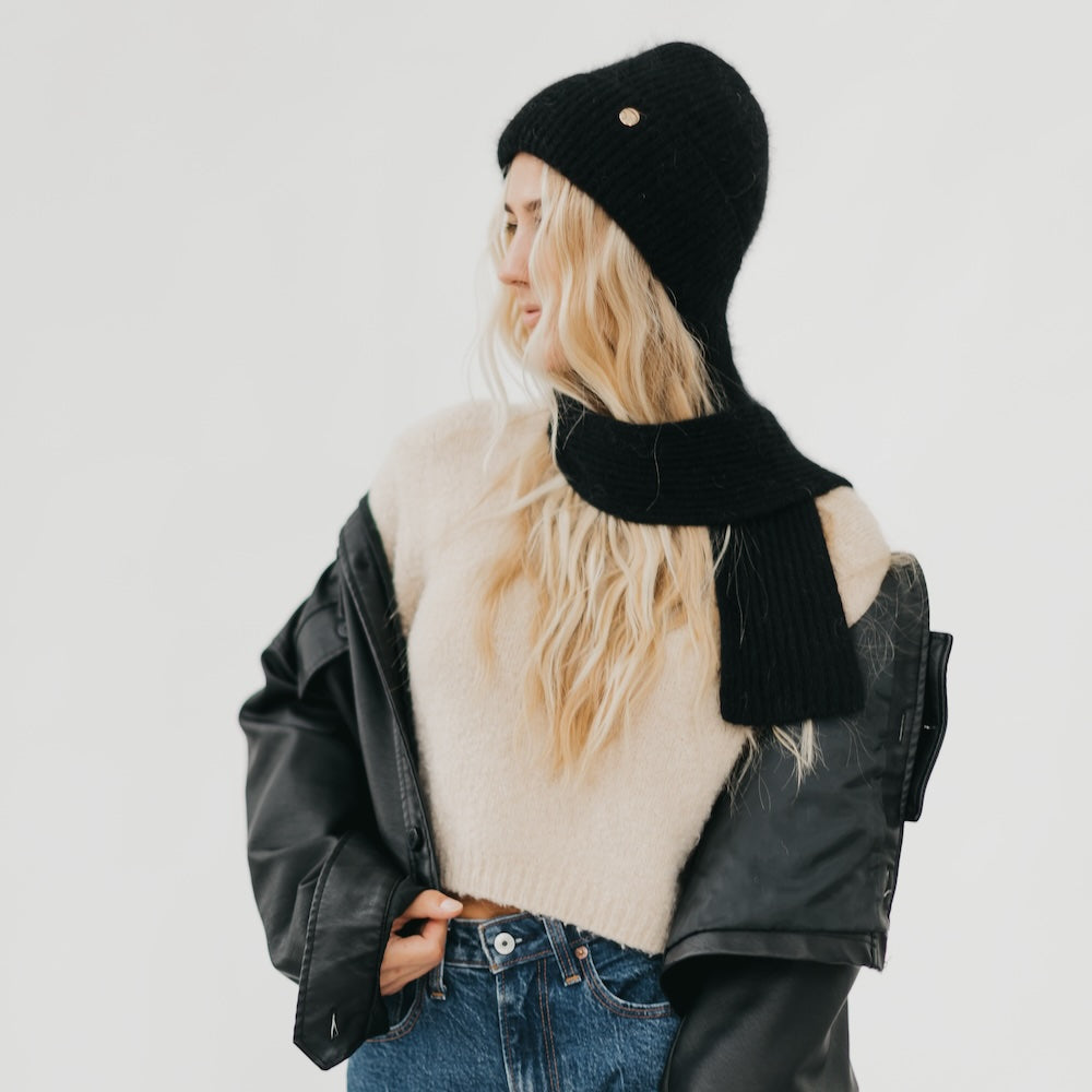 Black knitted beanie with matching black scarf wrapped around the neck