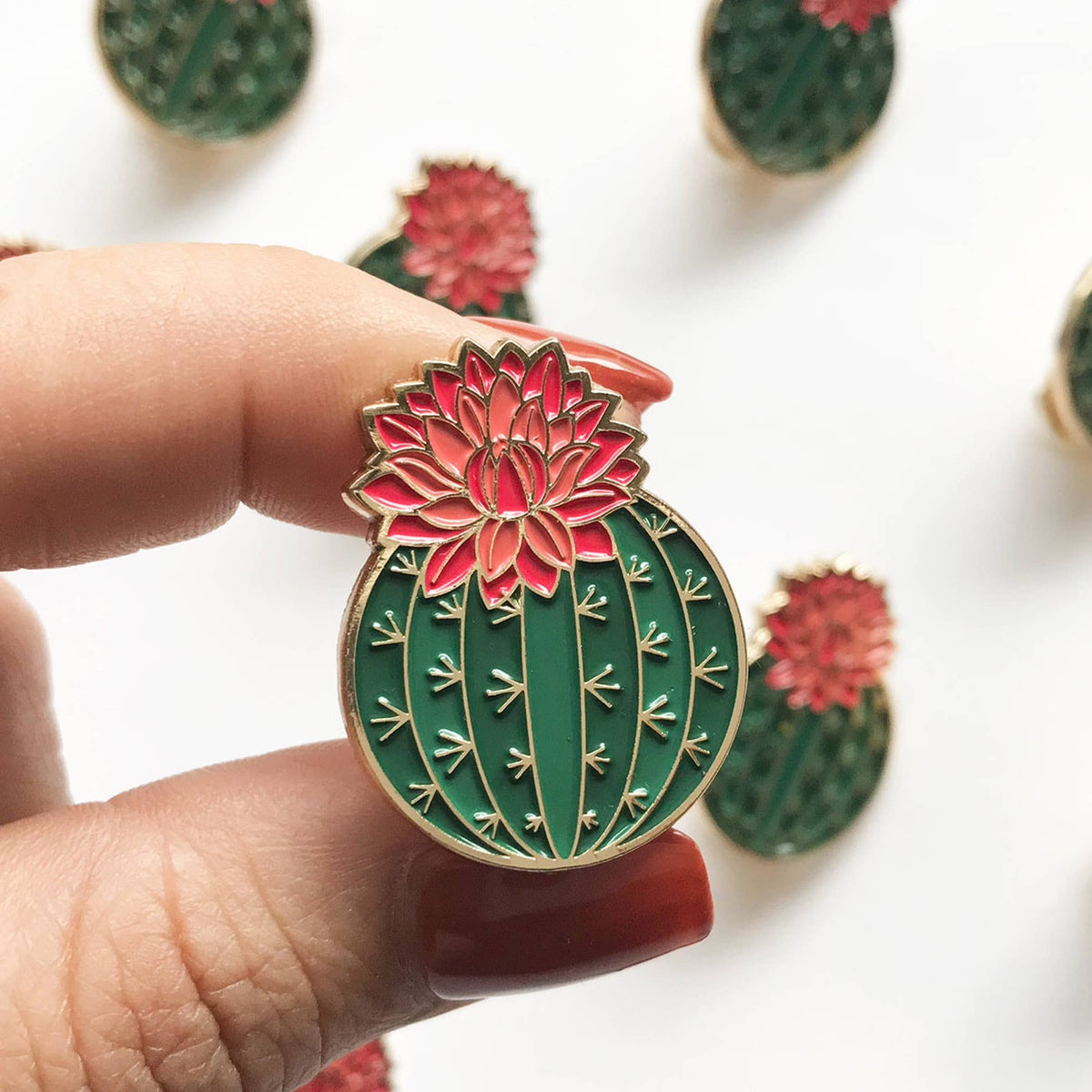 Green enamel cactus lapel pin with red blooming flower and gold-tone edges
