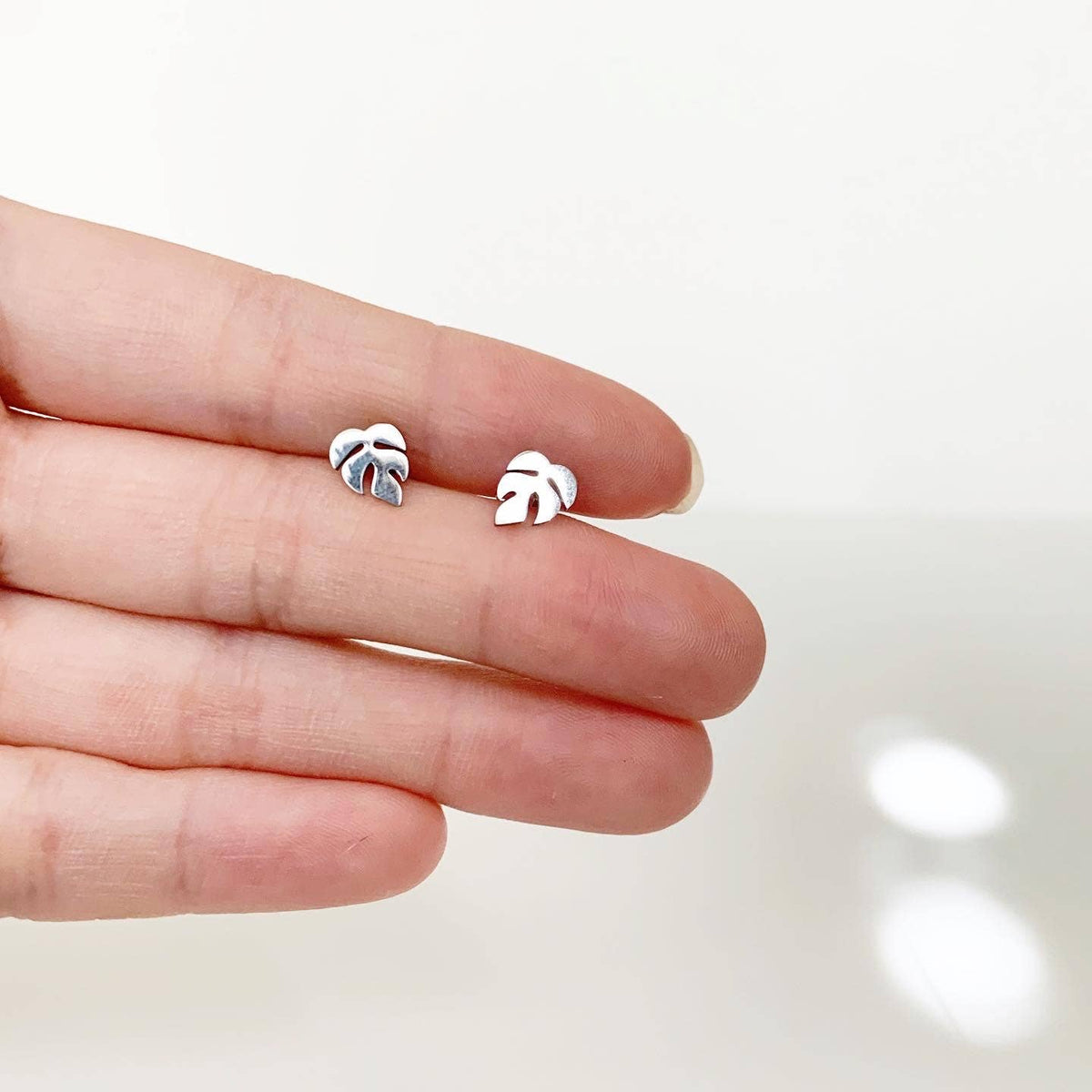 Leaf-shaped stud earrings in silver tone, small tropical motif on posts