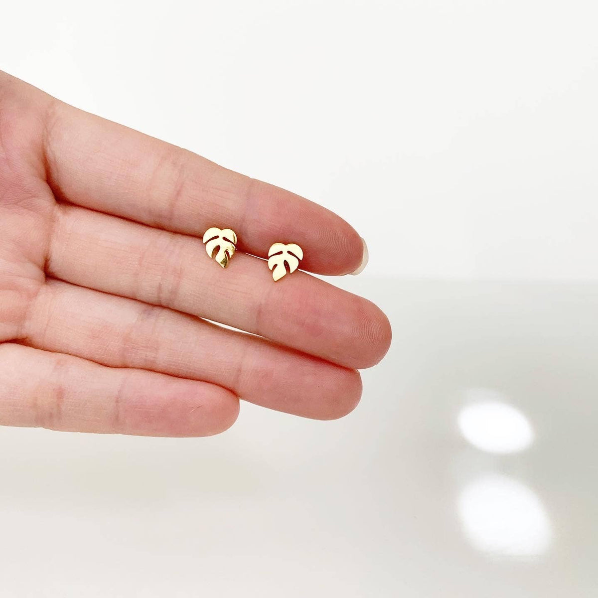 Leaf-shaped stud earrings in gold tone, small tropical motif on posts