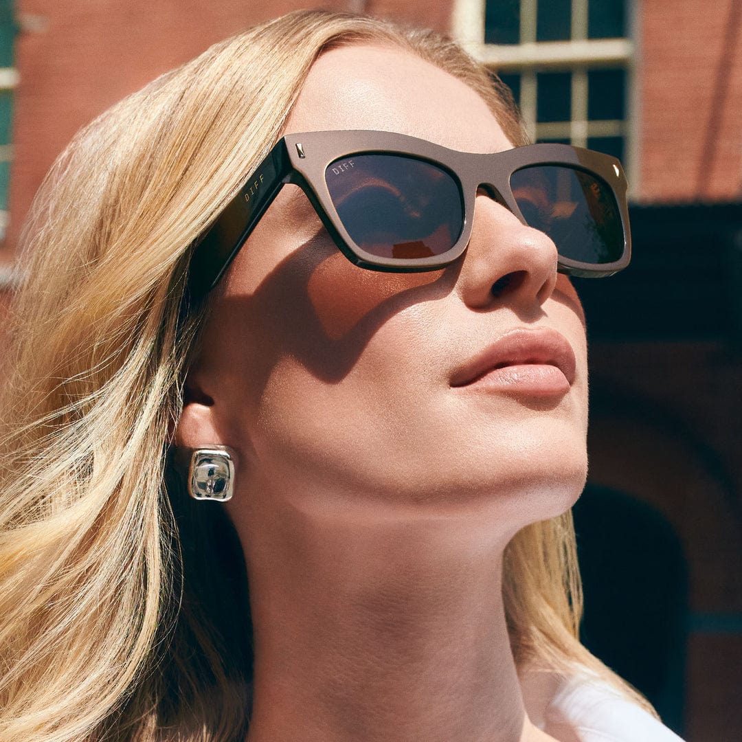Polarized sunglasses on model, dark square frames with tinted lenses and logo temples