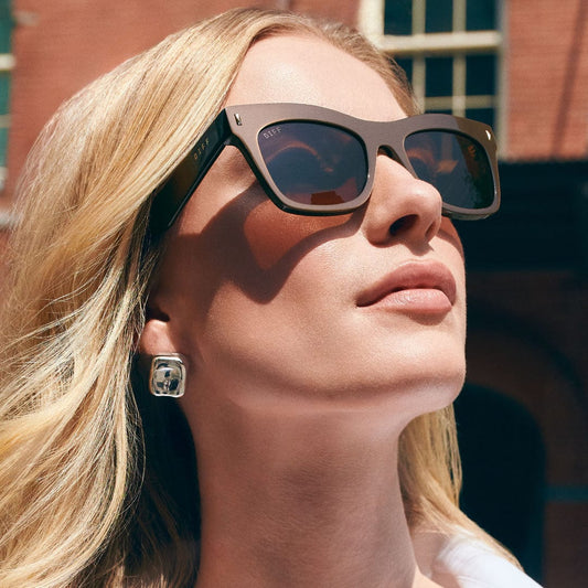Polarized sunglasses on model, dark square frames with tinted lenses and logo temples