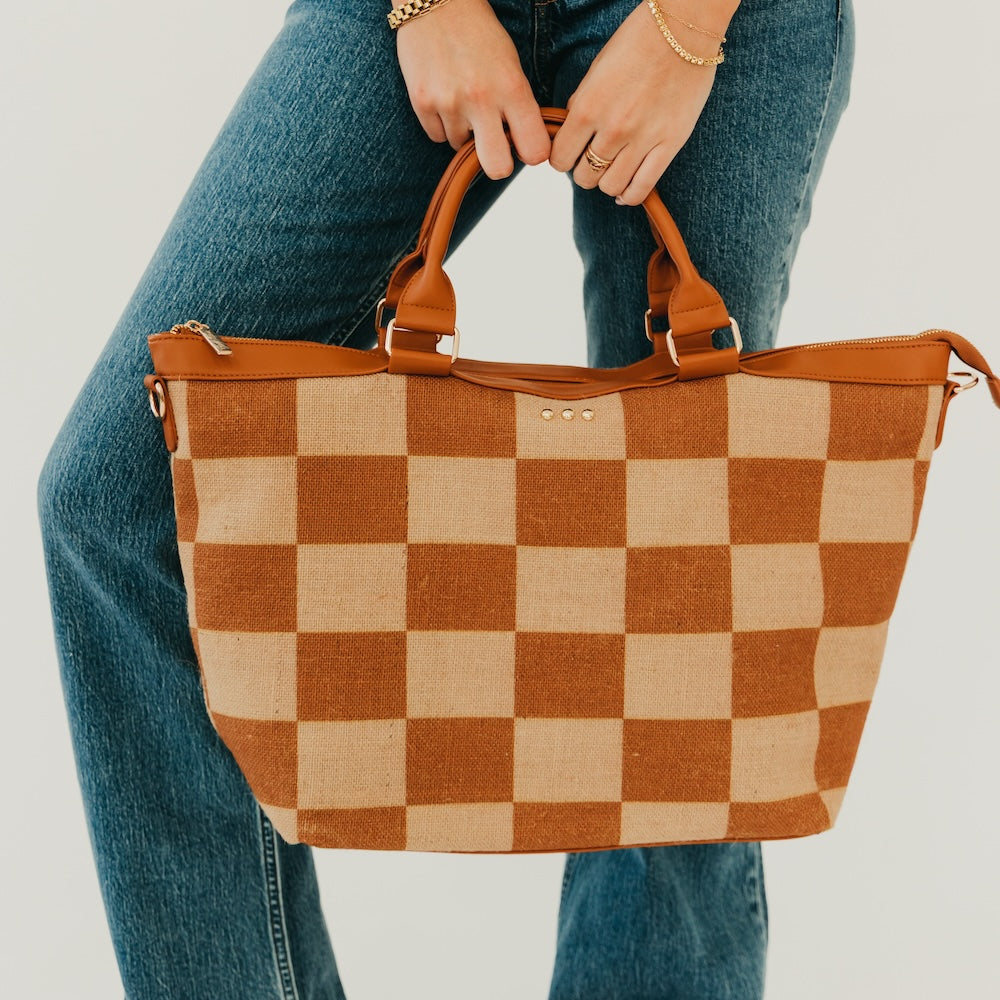 Jute tote bag with tan and brown checkered print, dual top handles and metal eyelets