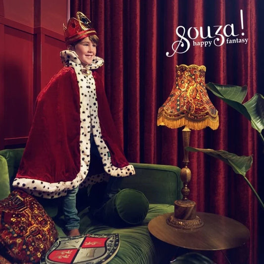 Child wearing burgundy king costume cloak with white spotted front and cape hood
