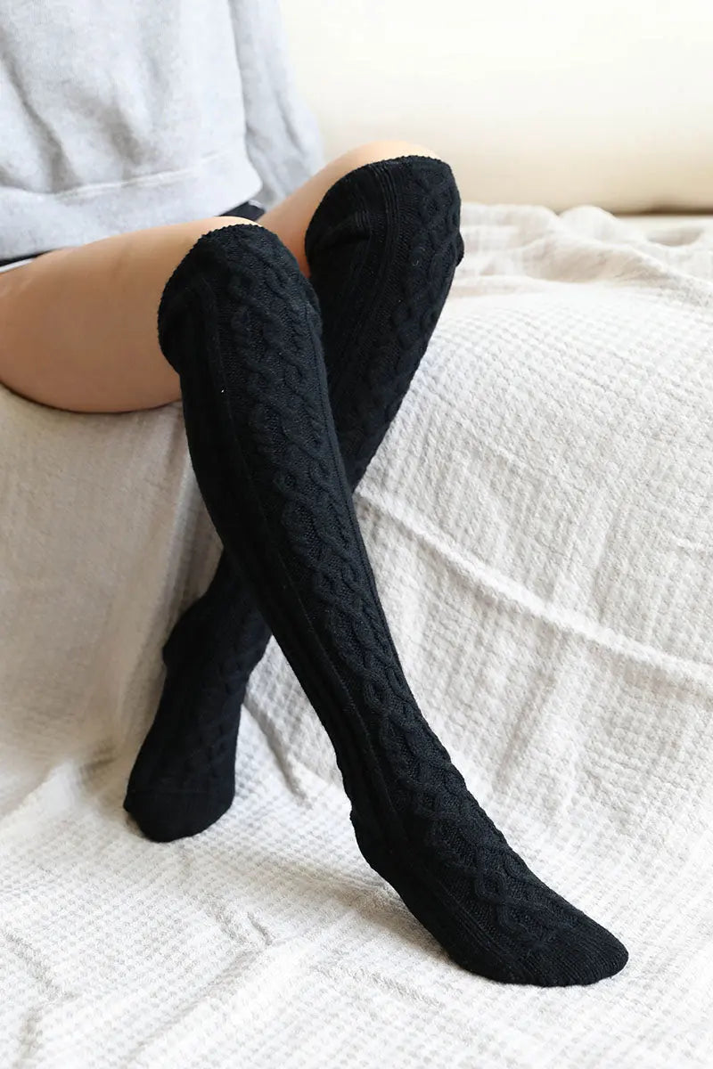 Black knee-high cable knit socks with thick cable stitch pattern