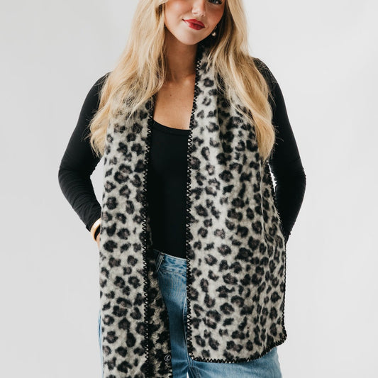 Leopard print scarf with black trim, draped open at the front