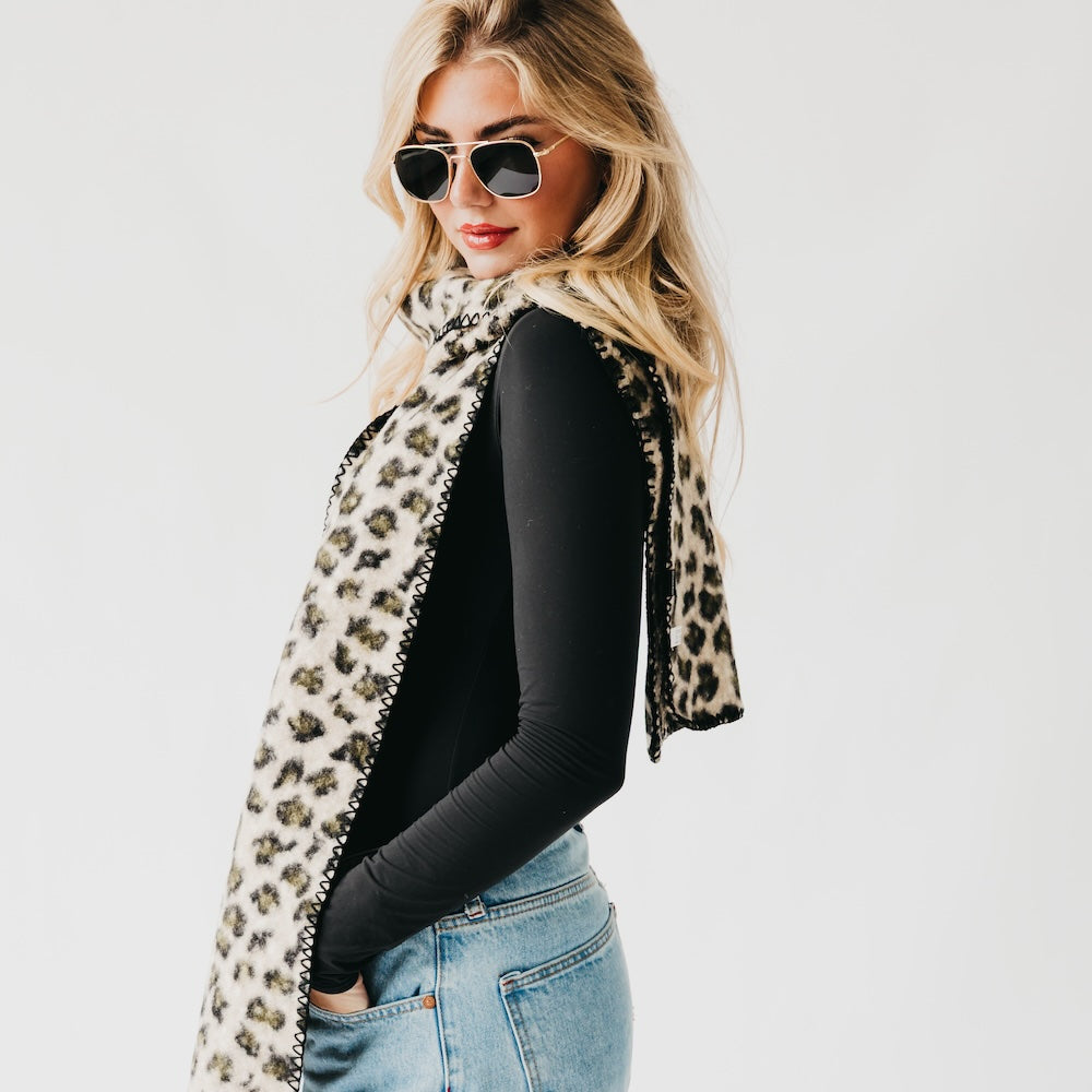 Leopard print scarf with black trim, side drape with one end falling down