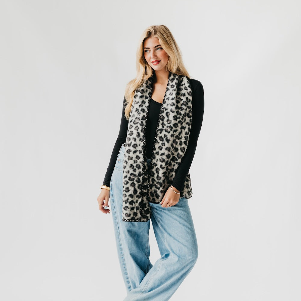 Leopard print scarf with black edge trim, hanging over the shoulder