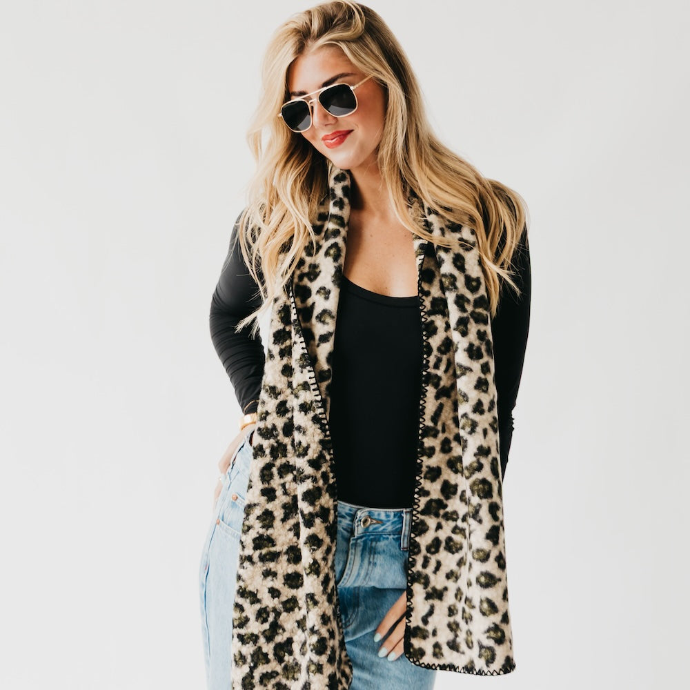 Leopard print scarf with black trim, symmetrical drape over the chest