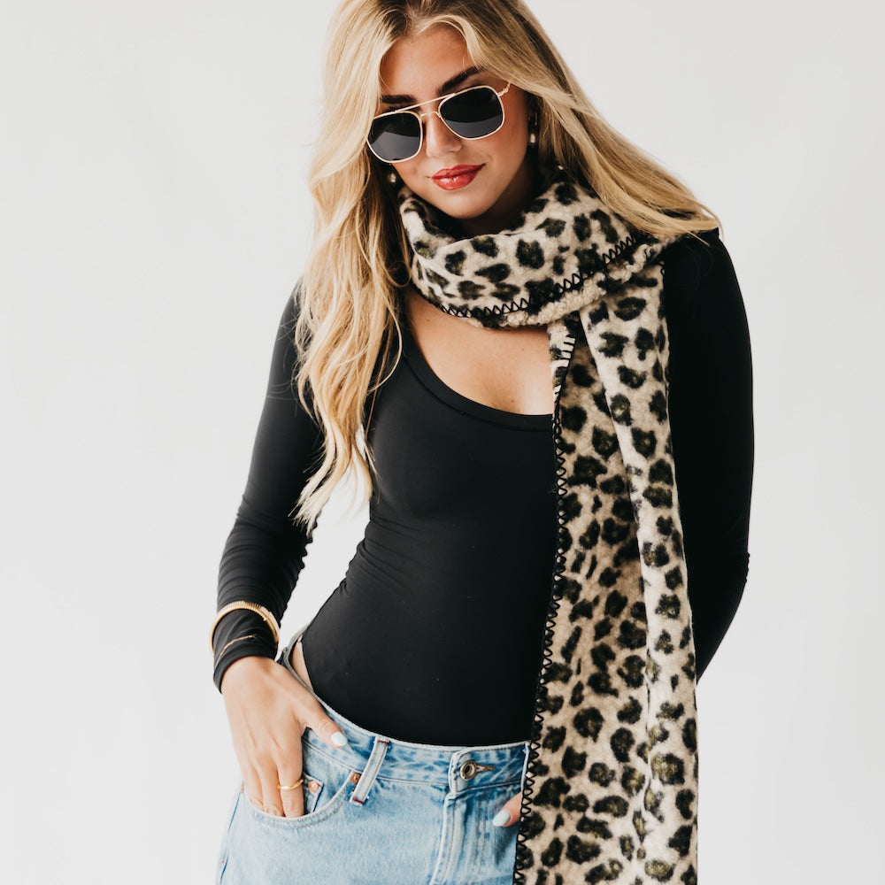 Leopard print neck scarf with black trim, wrapped snugly at the collar