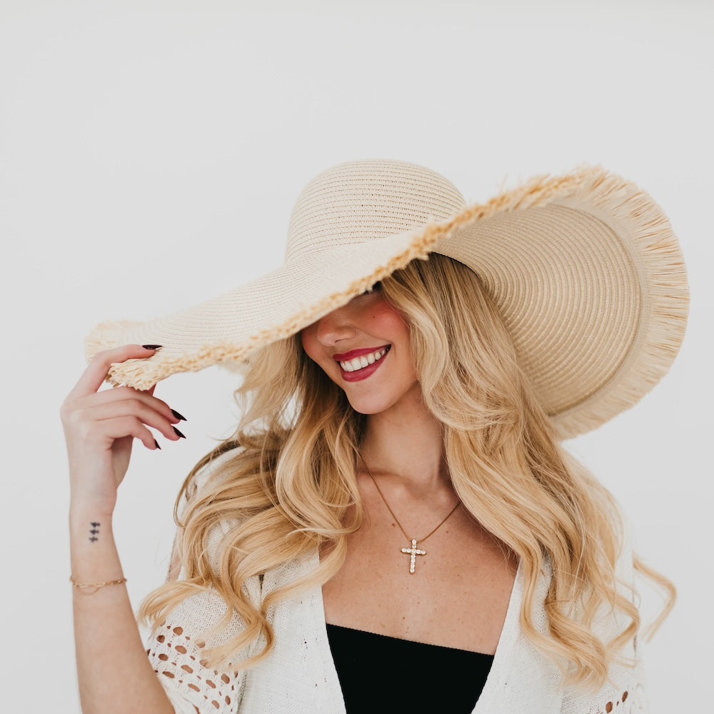 Light beige wide-brim sun hat featuring fringe trim around the brim edge