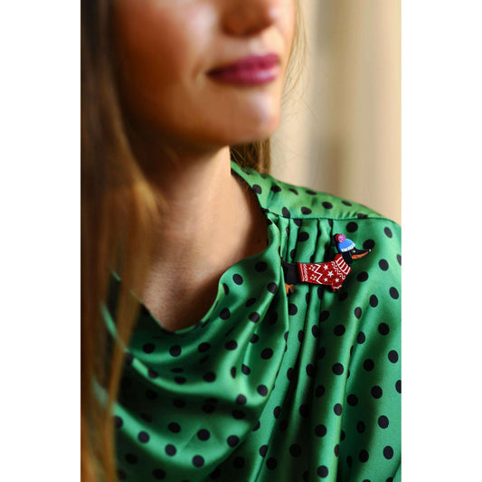 Dog brooch pinned to green polka-dot dress; red star sweater dachshund design