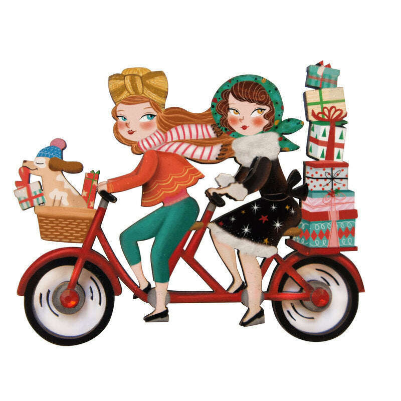 Enamel bicycle brooch: two women riding, one holding stacked gift boxes