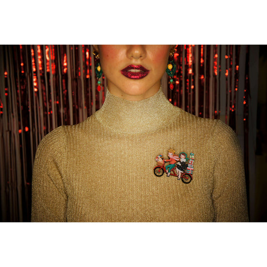 Small enamel bicycle brooch on a gold sweater, two riders with gift boxes