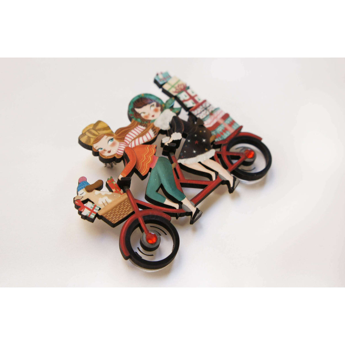 Bicycle enamel brooch with two women, stacked gifts on the rear rack