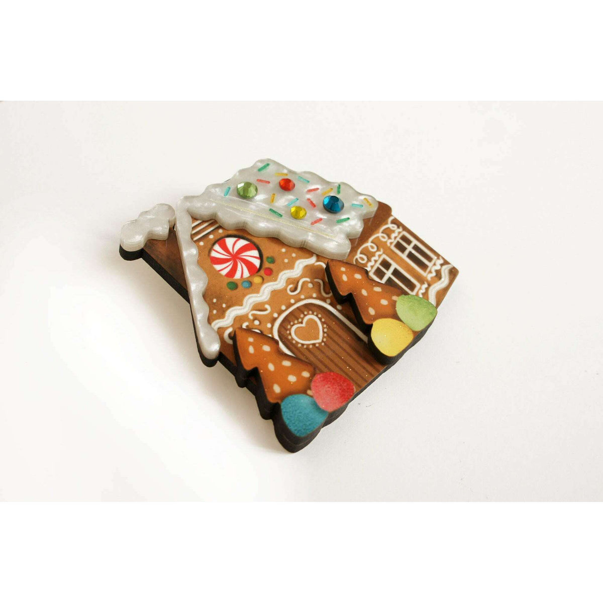 Gingerbread house enamel brooch with decorated roof, peppermint window, and candy front