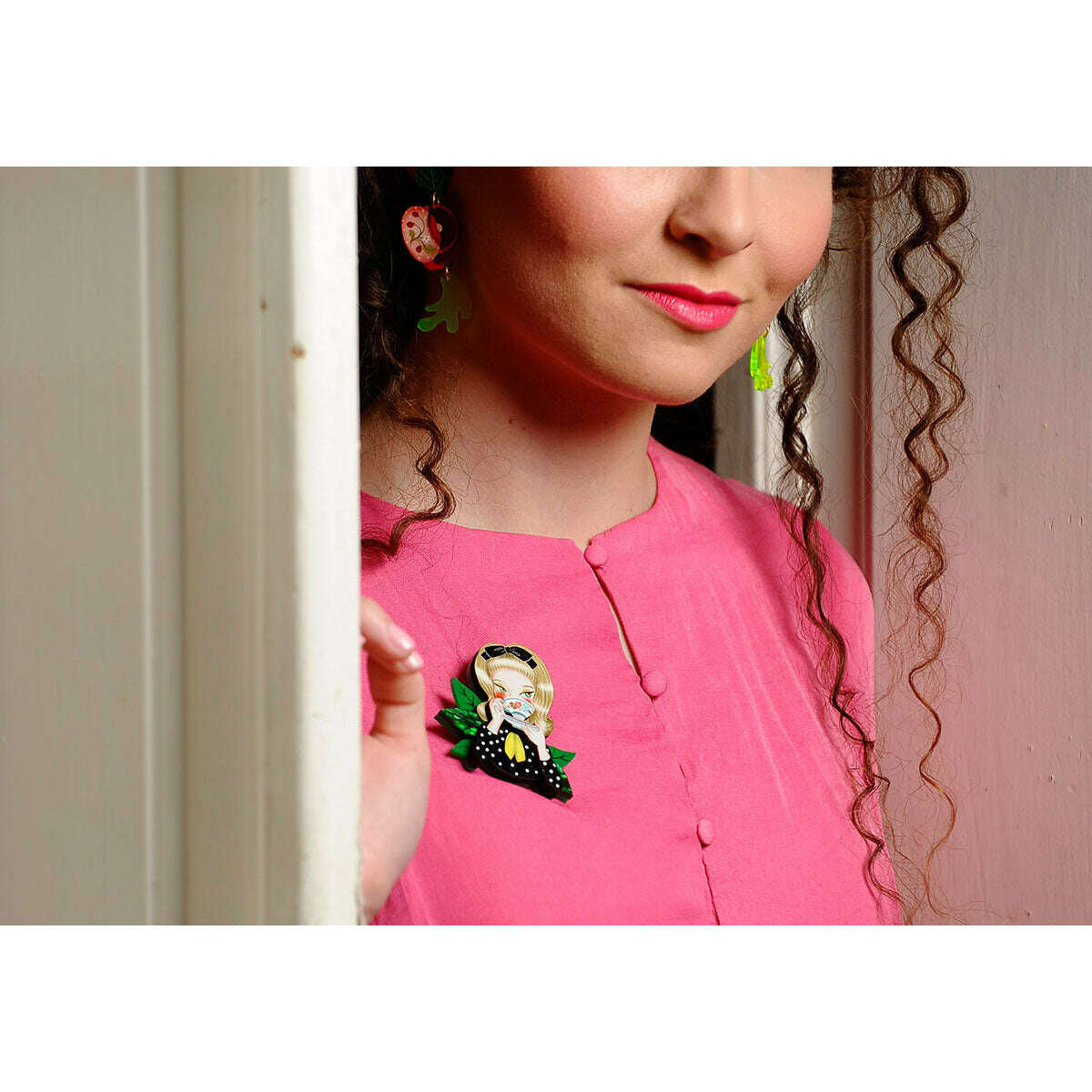 Girl tea-drinking brooch pinned on pink top near the chest