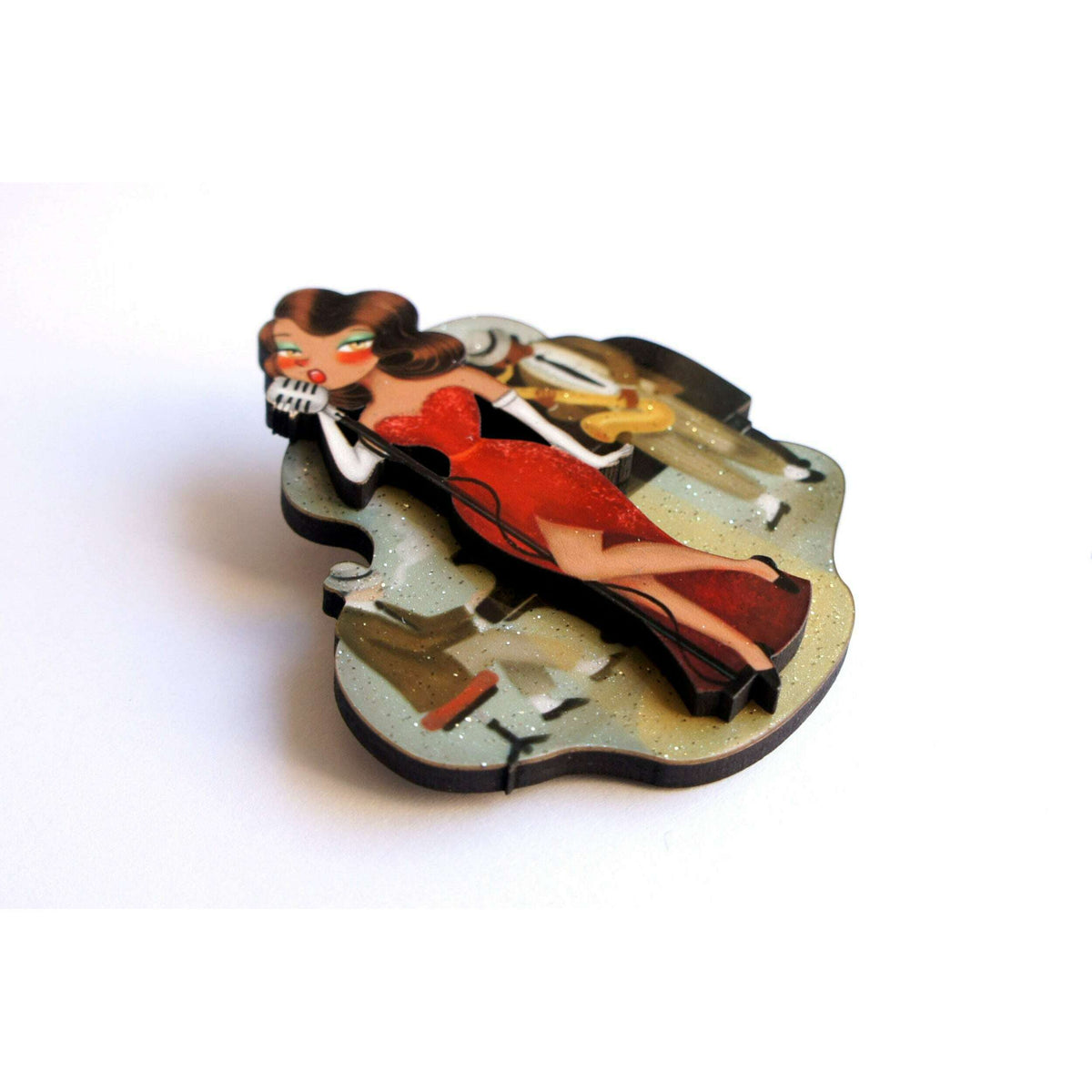 Jazz concert brooch, side view of red-dressed singer with microphone and band