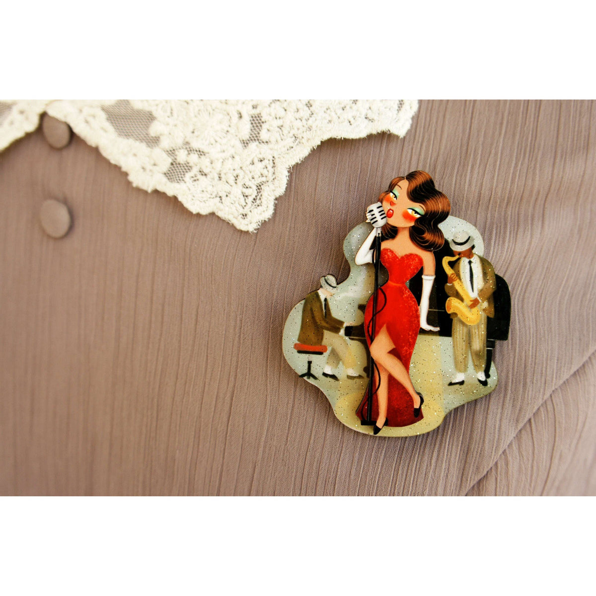 Jazz concert brooch featuring singer in red dress holding a microphone