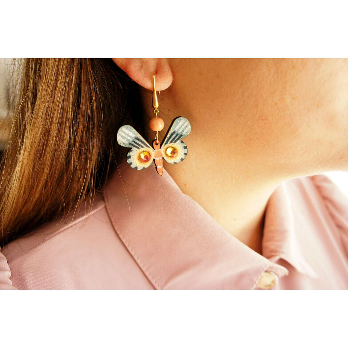 Multicolor butterfly drop earrings on gold hook with orange bead and blue wings