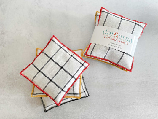 Windowpane linen lavender sachets, folded squares with red trim and black grid pattern