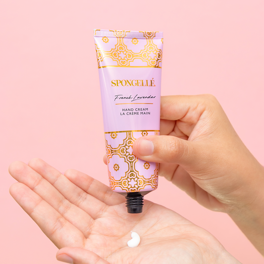 SPONGELLE French lavender hand cream tube with white cream on open palm.