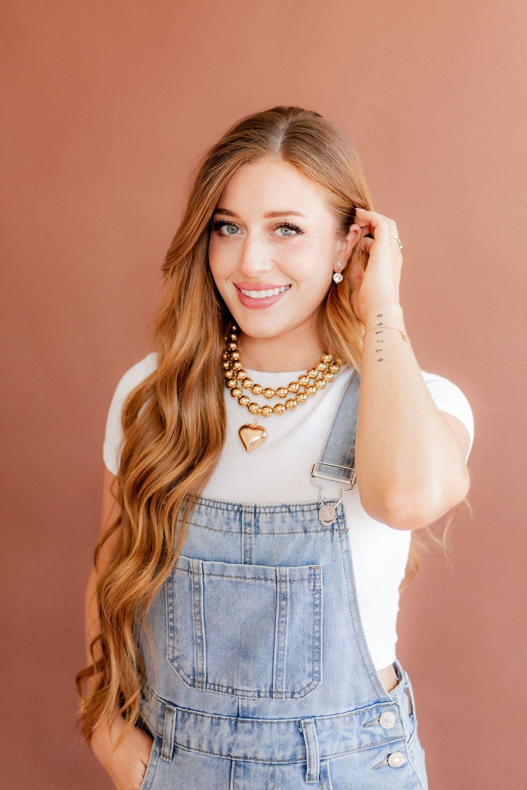 Pearl drop statement earrings featuring three white pearls on gold hooks