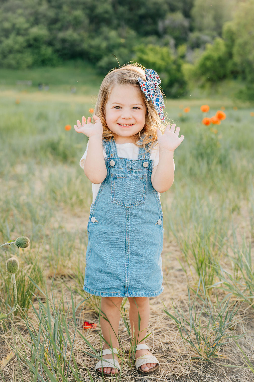 Floral hair bow on a child’s hair, cream with blue and red flower print