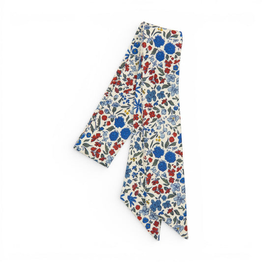 Floral hair sash with liberty-style blossoms on cream background, long ribbon ends