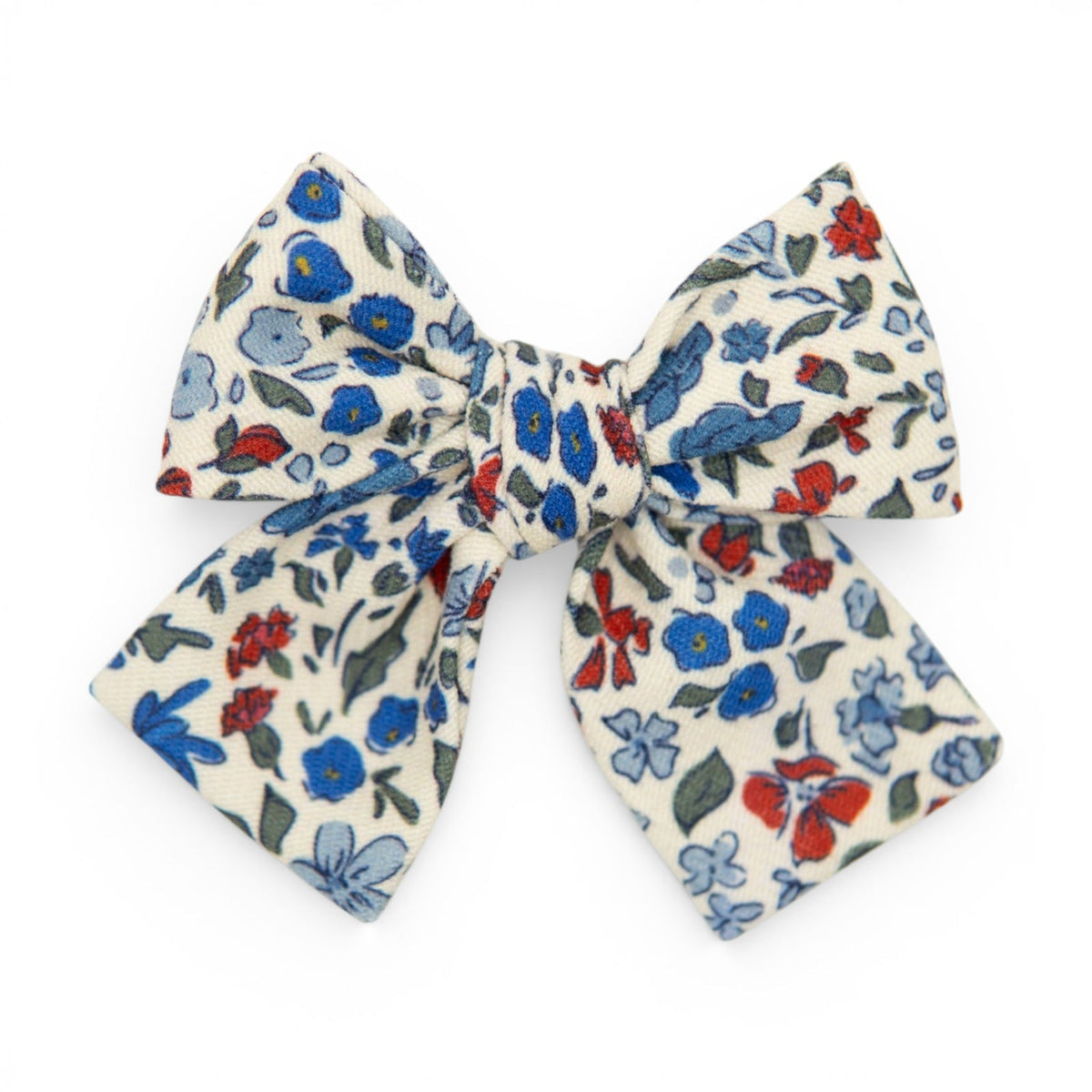 Floral petite hair bow in cream with blue, red, and green flower pattern