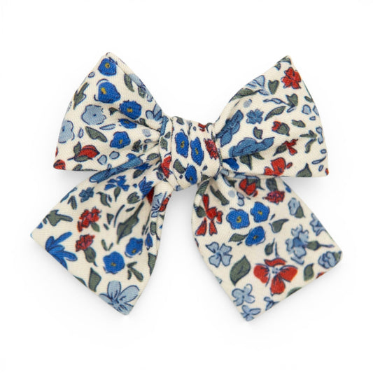 Floral petite hair bow in cream with blue, red, and green flower pattern