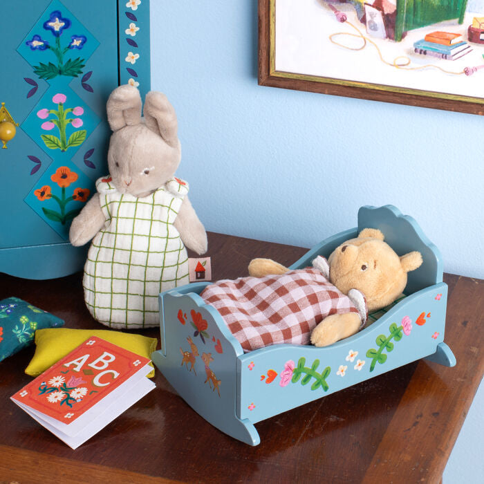 Plush rabbit doll wearing a white dress with a green grid and red flower details