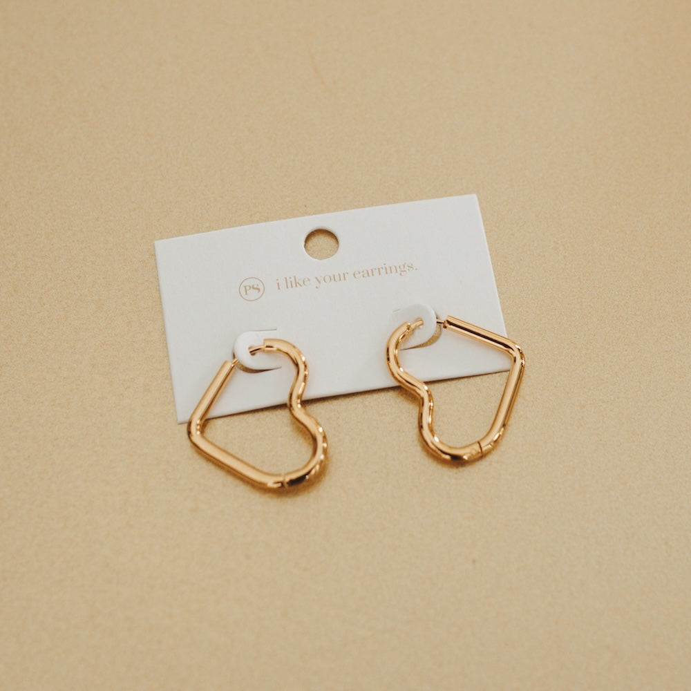 Gold-tone heart hoop earrings on a card with open heart silhouette.