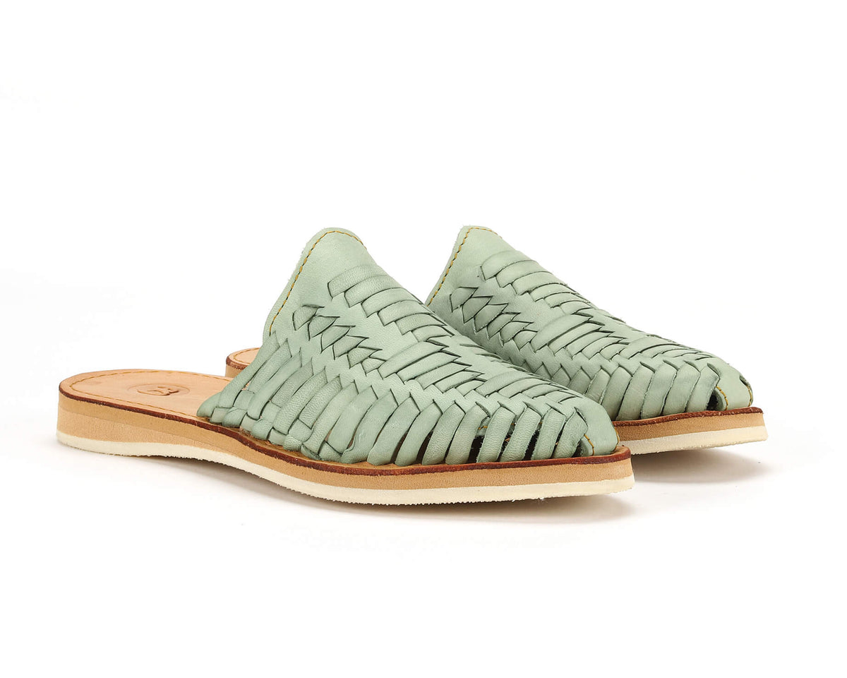 Pair of teal woven slip-on huarache slide sandals with tan rubber soles