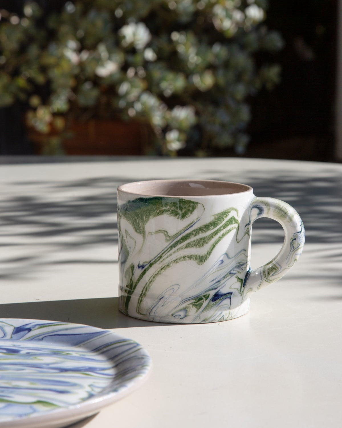 Marbled ocean mug in white with green and blue marbled pattern and right-side handle