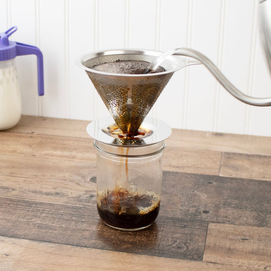 Pour-over coffee filter cone over Mason jar with brewed coffee dripping