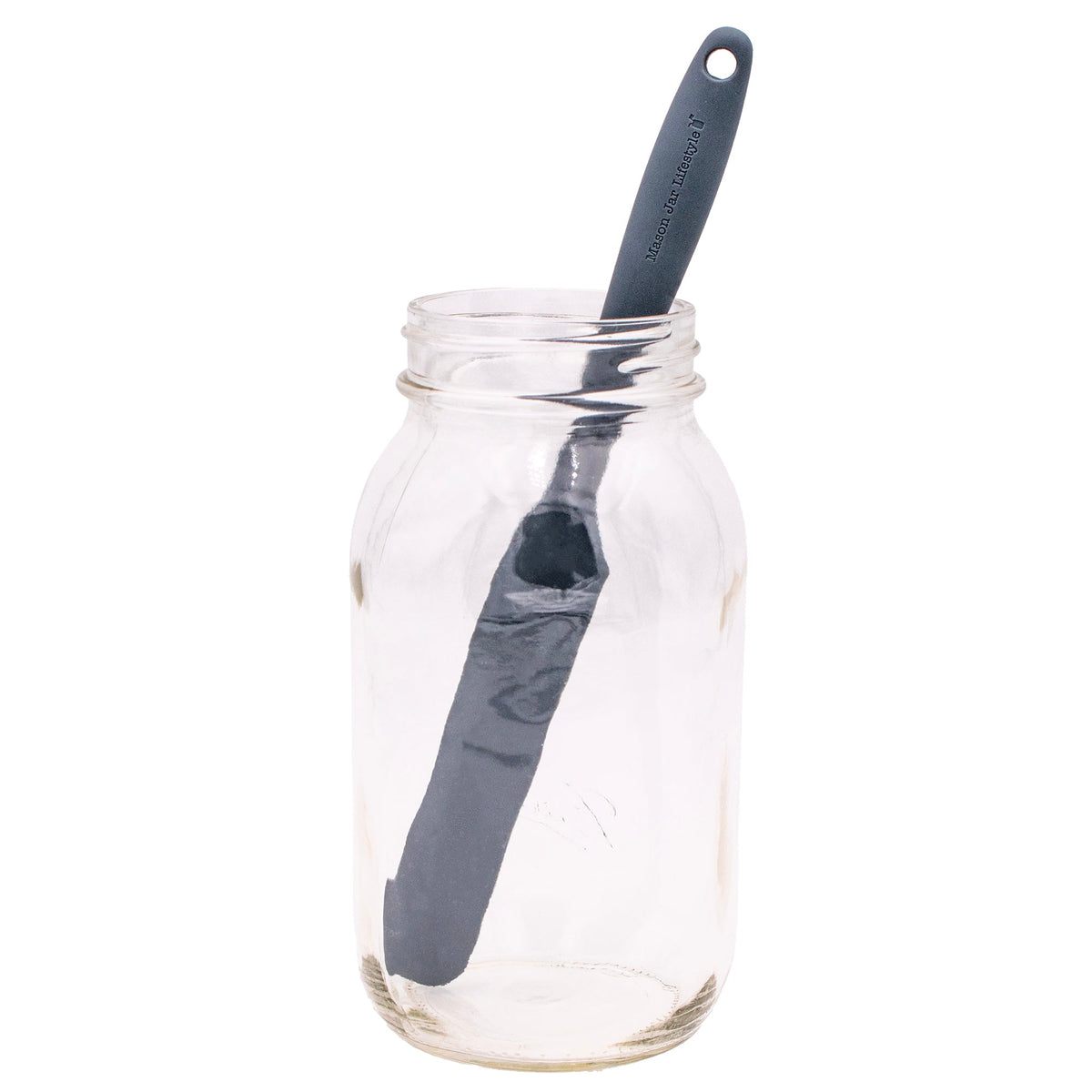 Gray silicone jar scraper standing inside a clear glass jar