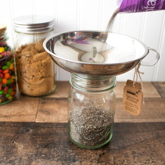 Stainless steel canning funnel over a mason jar, centered with pouring spout