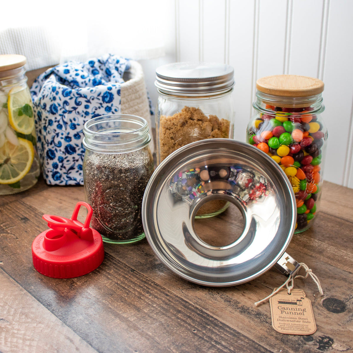 Stainless steel canning funnel with spout and tag attached, resting on jar mouth