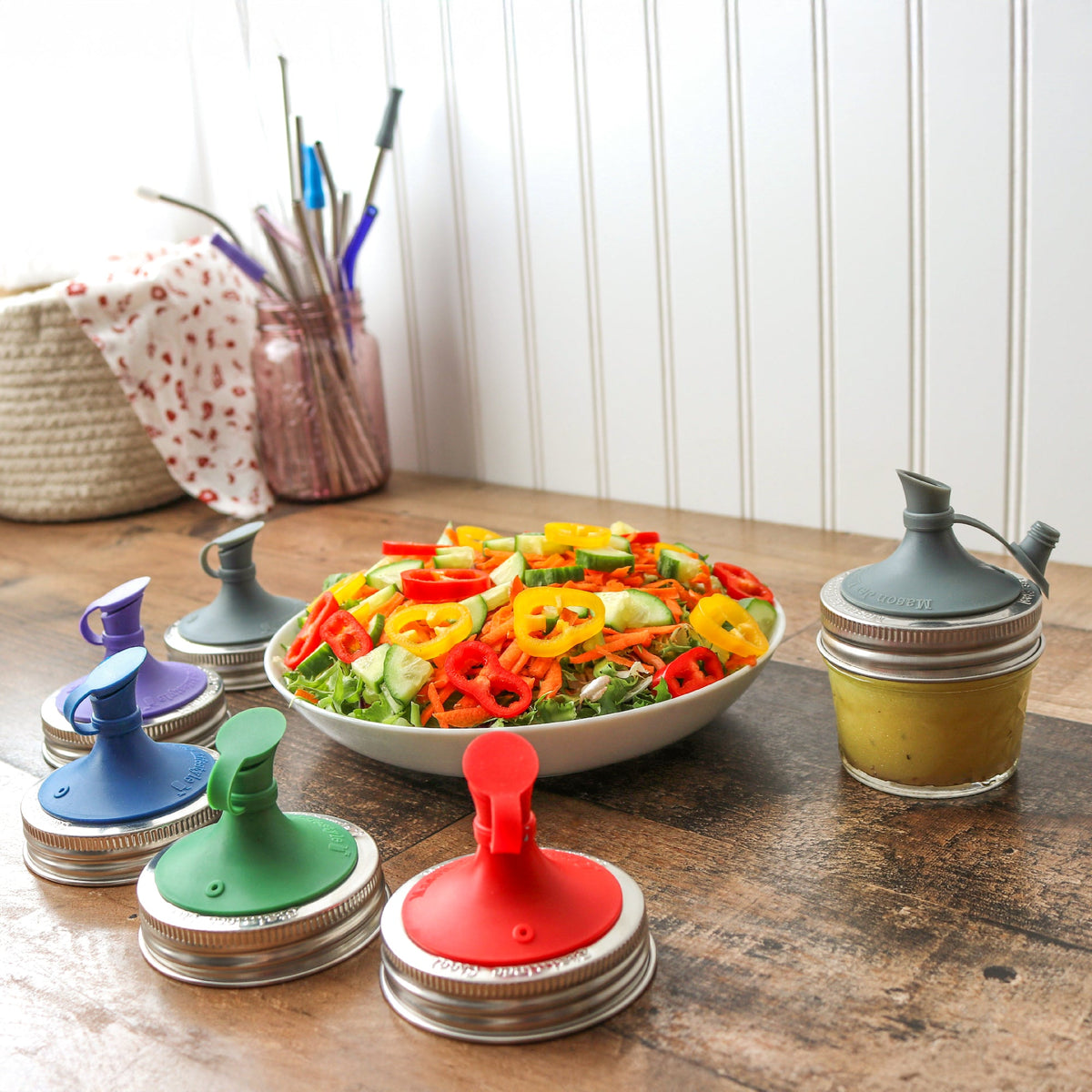 Colorful silicone oil pour lids in several shades with mason jar bands
