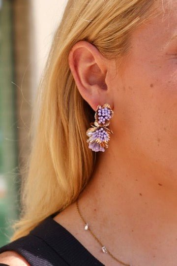 Purple flower cluster hoop earrings in gold-tone, dangling from hoop
