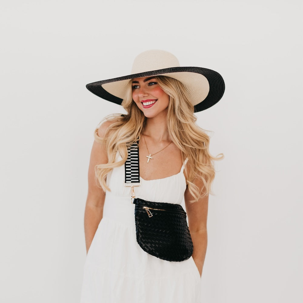 Wide floppy sun hat, tan crown with black brim edge and gold chain band, profile view