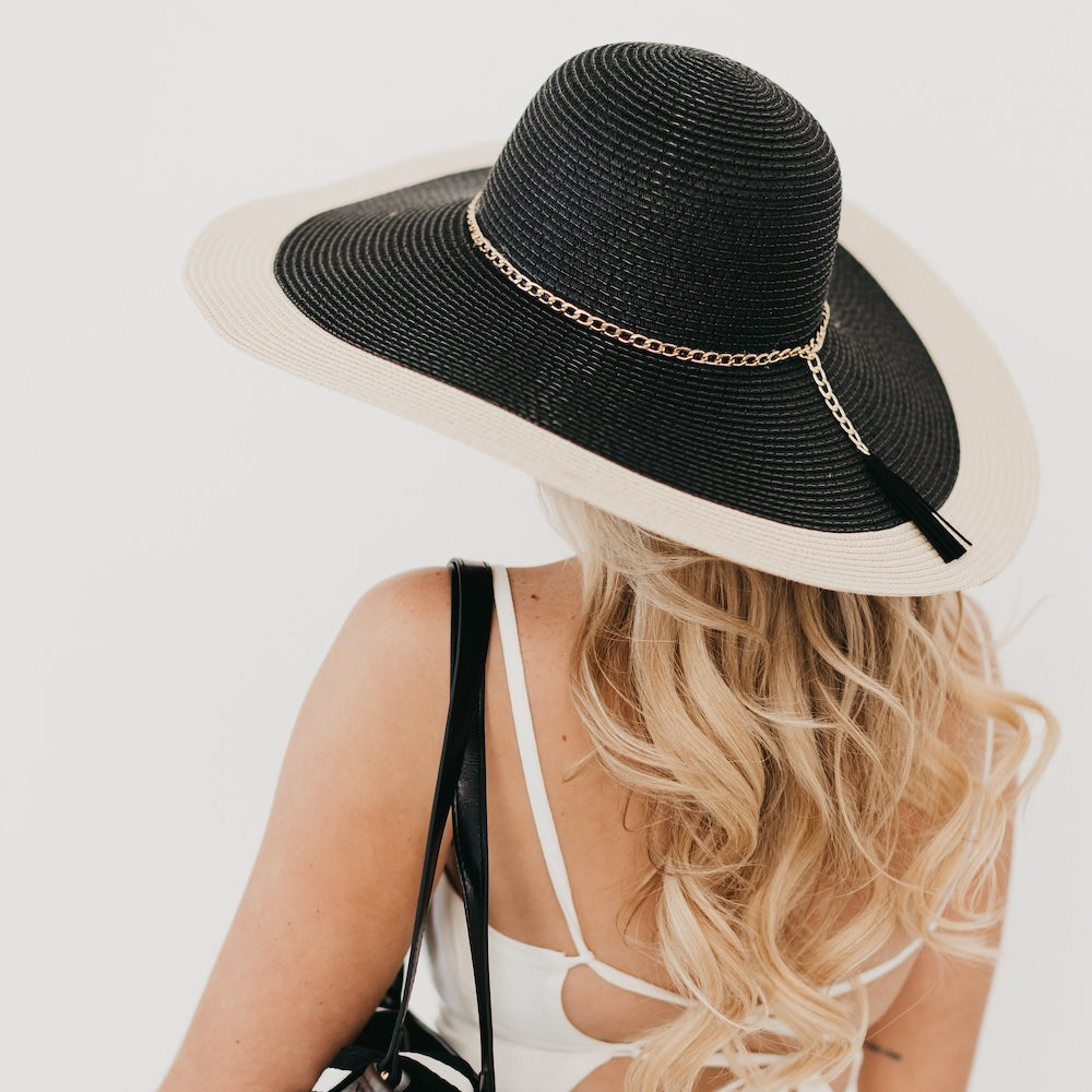 Two-tone wide floppy sun hat, black crown with tan brim and gold chain band, side/back view