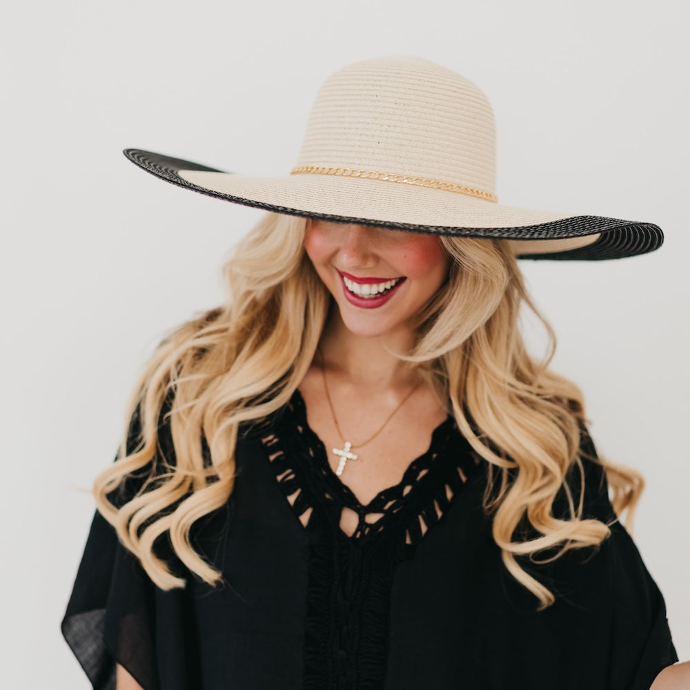 Wide floppy sun hat, tan crown with black brim trim and gold chain band, front view