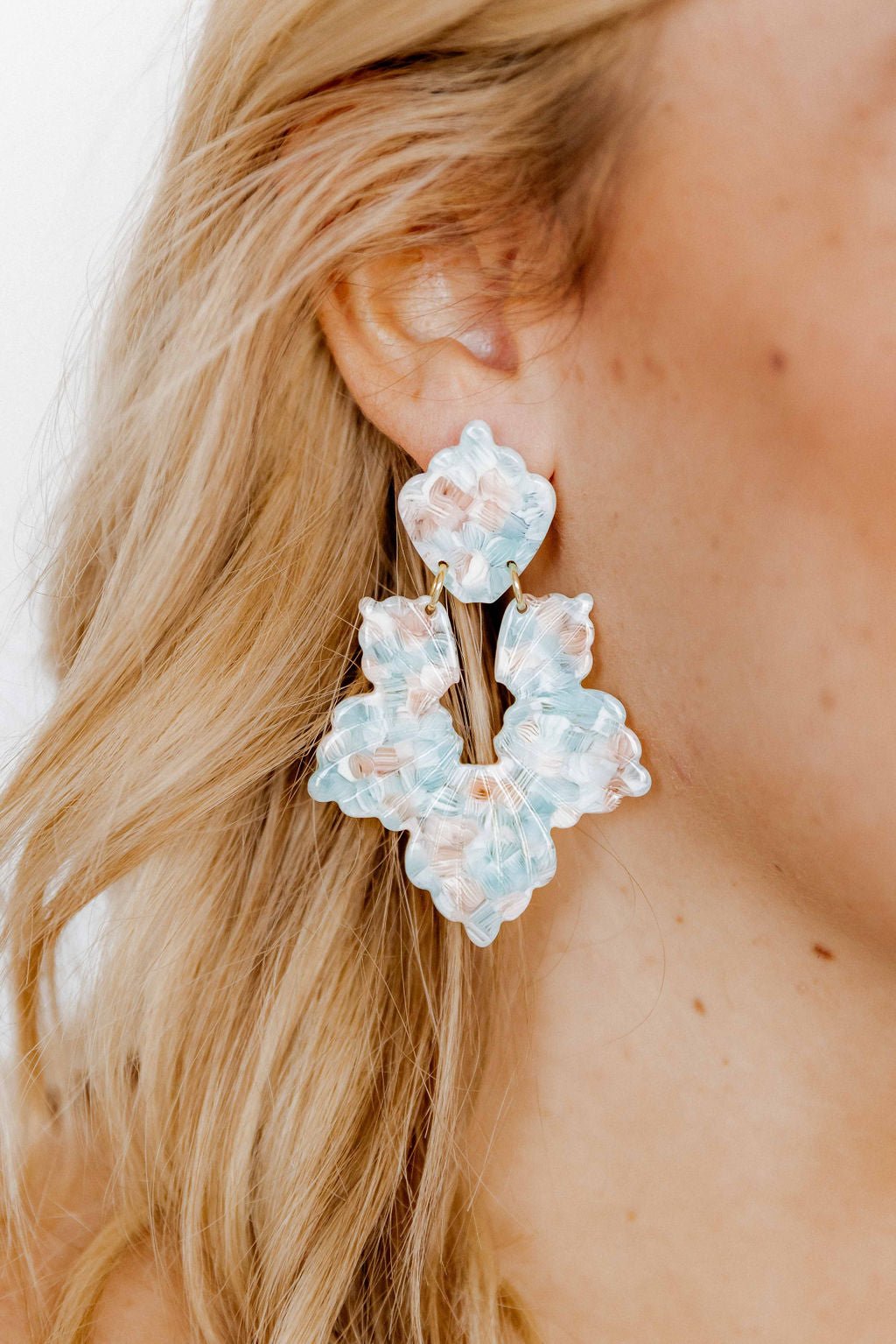 Mint shell drop earrings with layered light blue floral shapes and small peach beads