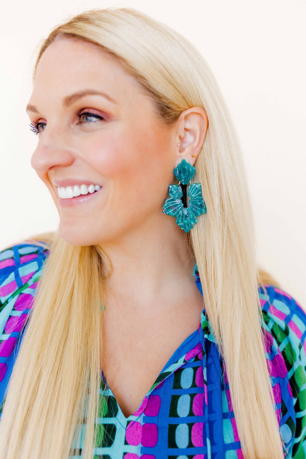 Close-up of turquoise floral statement dangle earrings with textured petal detailing