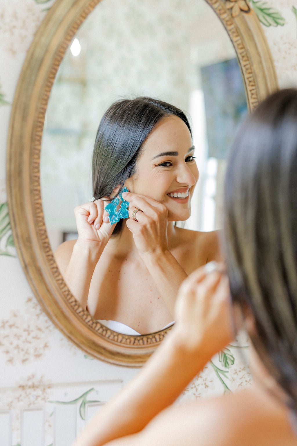 Turquoise floral statement dangle earrings on model, side view near chin
