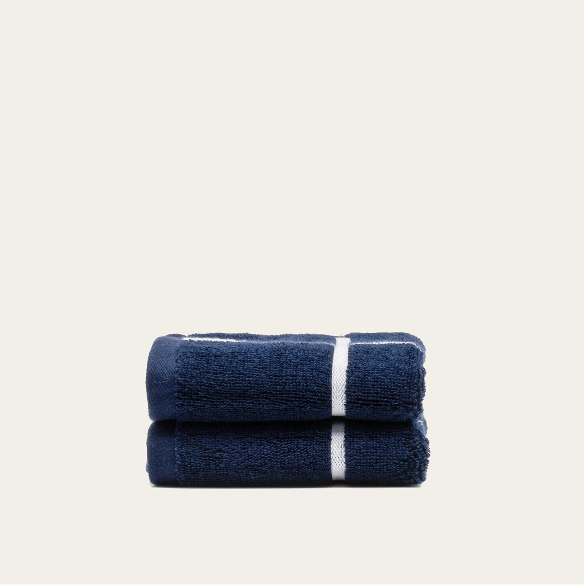 Navy cotton towels folded with a single white stripe across the center.