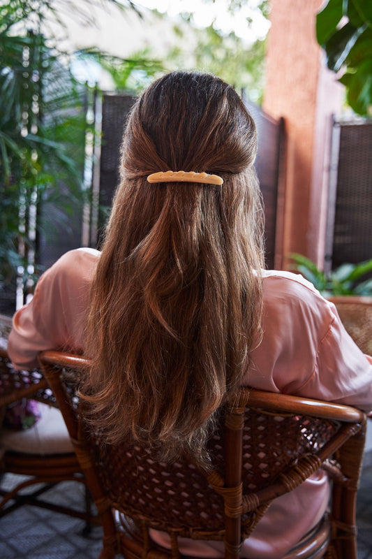 Cream baguette hair barrette clipped on long brown hair from the back