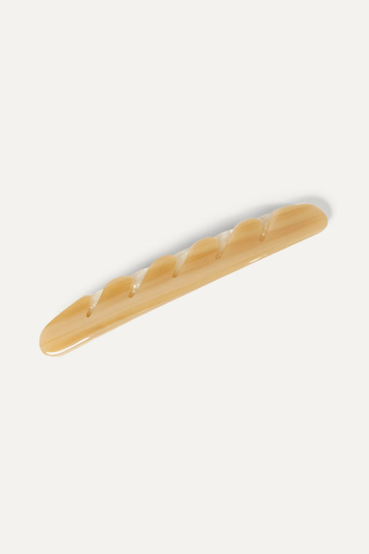 Cream baguette hair barrette with smooth glossy finish, close-up